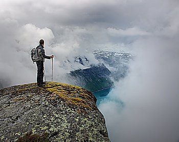 Man with hiking equipment standing on rock´s edge