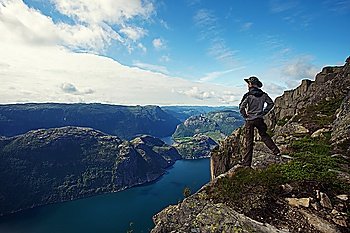 Man hiker looking over fjord panorama