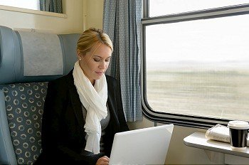 Woman using laptop traveling by train commuter serious technology reading