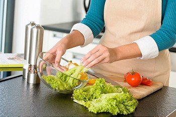 Woman preparing salad bowl vegetables kitchen cooking food hands