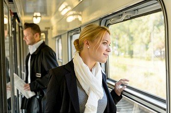 Woman looking out the train window traveling smiling commuter pensive
