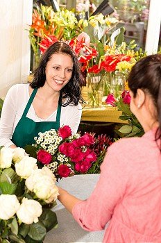 Happy florist making roses bouquet women customer buying flower shop