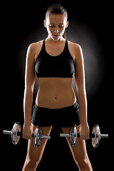 Fitness young woman holding adjustable dumbbells on black background