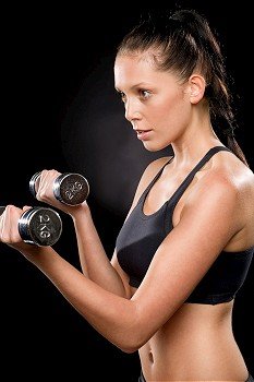 Half length of a young woman lifting dumbbells in sportswear