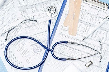 Medical equipment on doctor´s office desk stethoscope patient documents