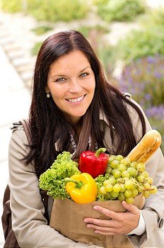 Smiling woman shopping vegetables groceries paper bag standing