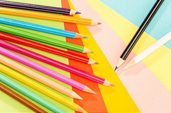 Color pencils on colorful papers close-up creativity concept