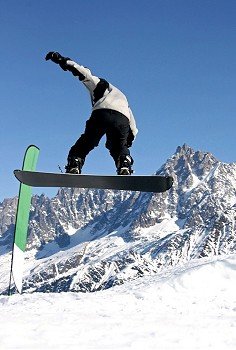 A snowboarder jumping freestyle in the mountains