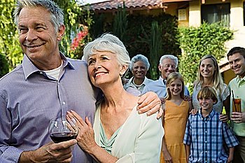 Senior couple celebrating with family and friends in garden