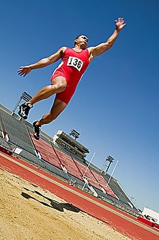 Male athlete long jumping, mid-air