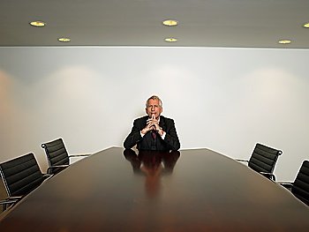 Businessman sitting alone in conference room