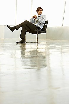 Businessman sitting in empty conference room