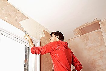 Man Scraping Paint Off Wall