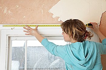 Woman Measuring Top of Windowsill