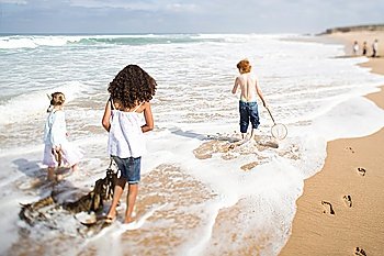 Three children walking on beach