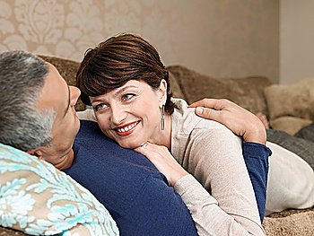 Smiling couple relaxing on sofa in living room