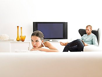 Woman on sofa and man in armchair in modern living room
