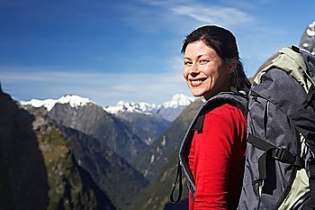 Female hiker wearing backpack on mountain peak