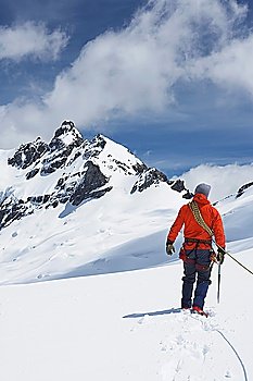 Hiker connected to safety line in snowy mountains back view