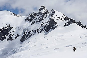 Hiker headed for distant peak in snow back view