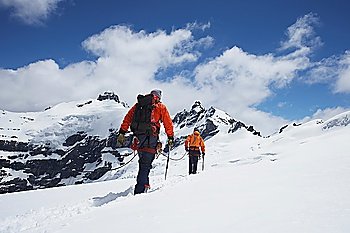 Hikers joined by safety line in snowy mountains back view