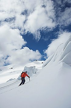 Hiker going up snowy mountain slope