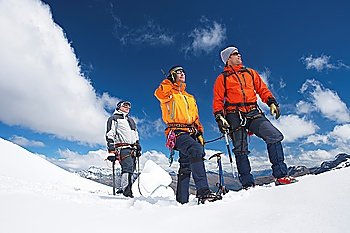 Three mountain climbers on snowy peak