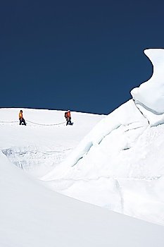 Mountain climbers walking past ice formation