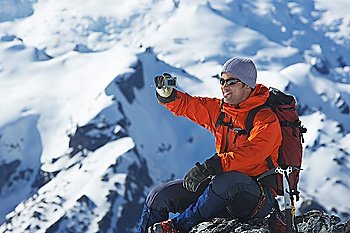 Mountain climber taking a picture on mountain peak