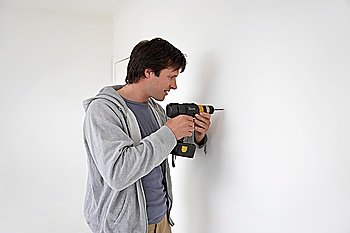Man drilling hole in wall
