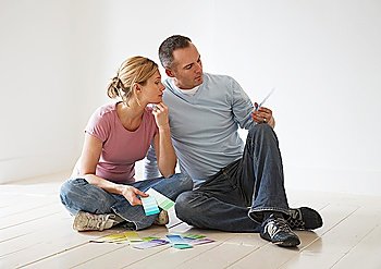 Couple sitting on floor looking at paint swatches