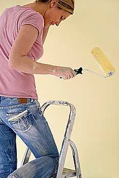 Woman on ladder with paint roller