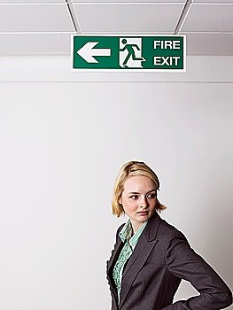 Businesswoman Standing Under Exit Sign