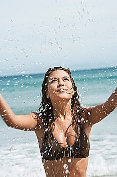 Young Woman Splashing in Surf at Beach