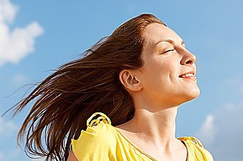 Young woman outdoors enjoying wind on face, close up