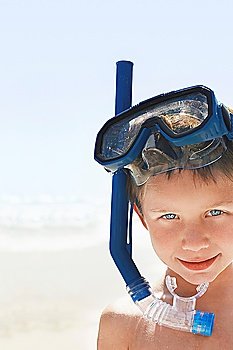 Boy (7-9) wearing snorkel and mask at beach, portrait