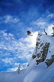 Skier jumping from mountain ledge