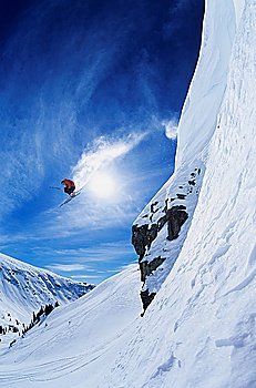 Skier jumping from mountain ledge