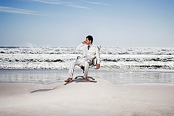Young Businessman Sitting in an Office Chair at the Beach