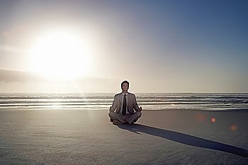 Young Businessman Meditating on the Beach