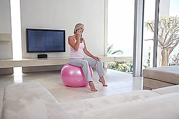 Woman Telephoning on Exercise Ball