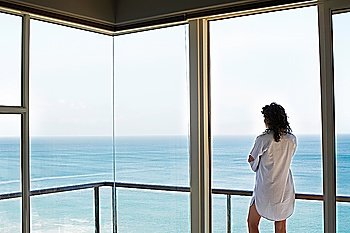Woman Looking Through Window at Ocean