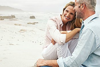 Couple sitting on beach smiling