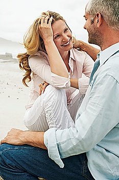 Couple sitting on beach smiling