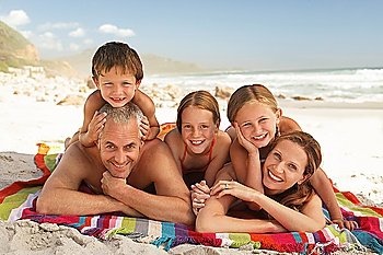 Family lying on beach.