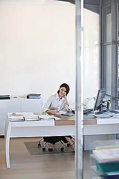 Businesswoman sitting at desk in office.