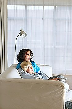 Boyfriend and girlfriend sitting on sofa watching television