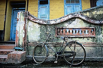 Old fashioned bicycle left by crumbling wall
