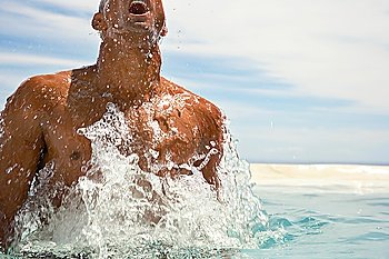 Man surfacing in swimming pool half length cropped