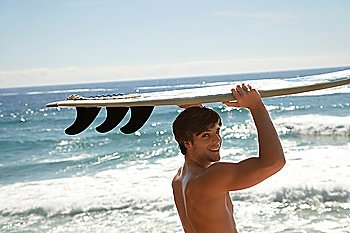 Man holding surfboard above head by ocean head and shoulders